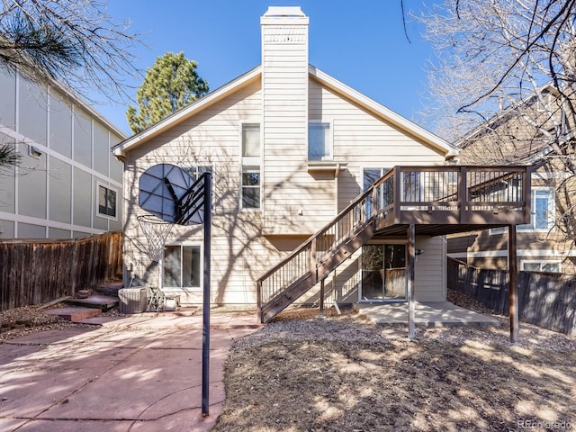 back of property with a deck, fence, stairs, a chimney, and a patio area