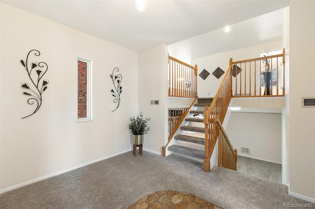 staircase with baseboards, visible vents, and carpet floors