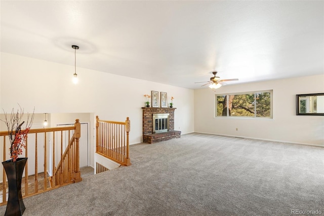 unfurnished living room featuring carpet, a fireplace, and a ceiling fan