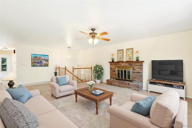 living room with baseboards, ceiling fan, and a fireplace