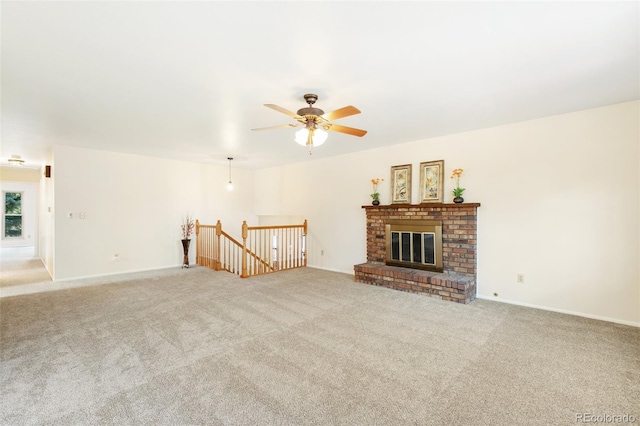 unfurnished living room with baseboards, carpet, a brick fireplace, and ceiling fan