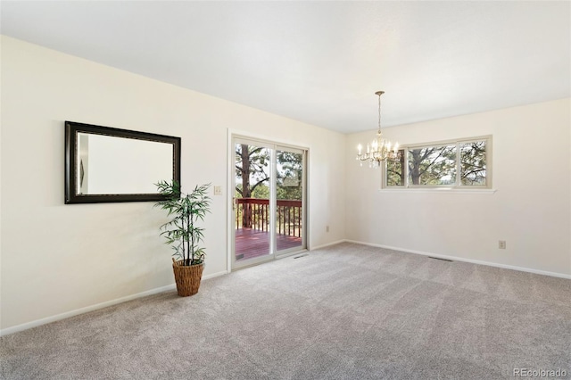 unfurnished room with a wealth of natural light, baseboards, a notable chandelier, and carpet