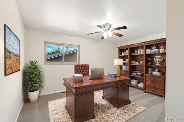 office space featuring baseboards, light colored carpet, and ceiling fan