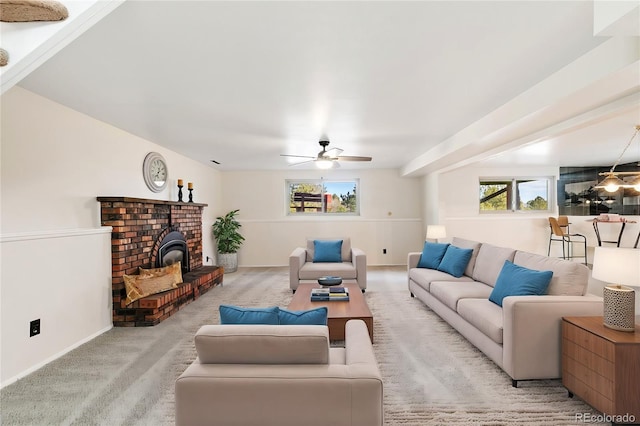 carpeted living area with a wood stove and a ceiling fan