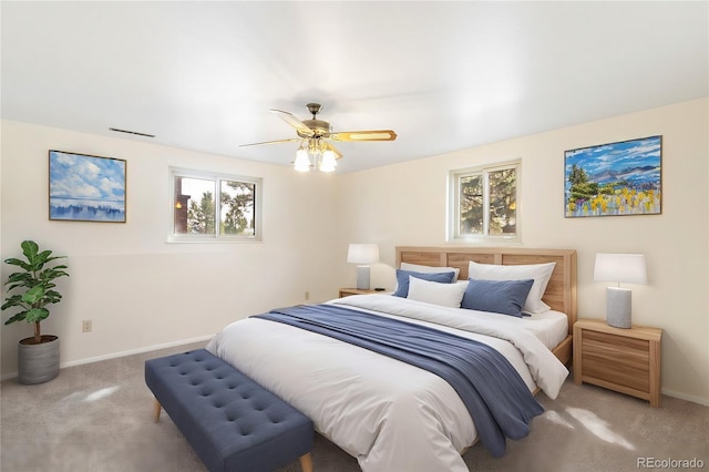 carpeted bedroom with visible vents, baseboards, and ceiling fan