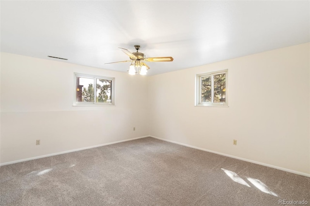 unfurnished room with baseboards, visible vents, a ceiling fan, and carpet