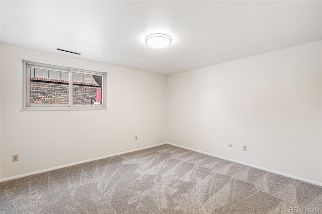 spare room featuring visible vents, baseboards, and carpet