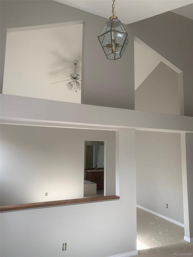 interior space with lofted ceiling and ceiling fan with notable chandelier