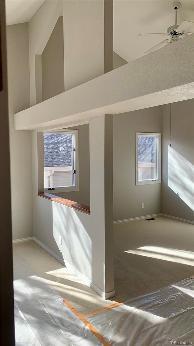 empty room featuring a high ceiling and ceiling fan