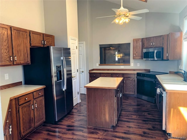 kitchen featuring stainless steel appliances, dark hardwood / wood-style flooring, sink, and a kitchen island