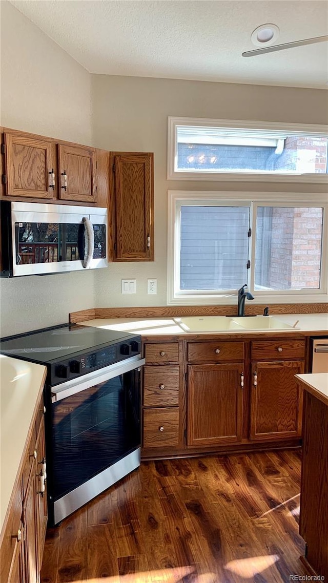 kitchen featuring dark hardwood / wood-style flooring, sink, a textured ceiling, and electric range