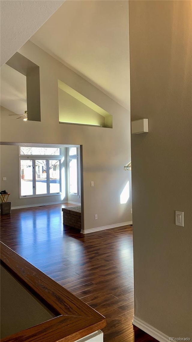 interior space with high vaulted ceiling, dark hardwood / wood-style floors, and ceiling fan