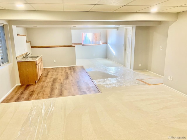 unfurnished room featuring sink, a drop ceiling, and light hardwood / wood-style flooring