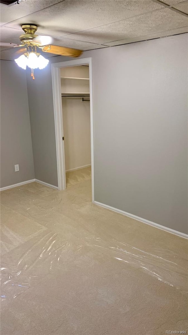 unfurnished bedroom featuring a spacious closet and ceiling fan