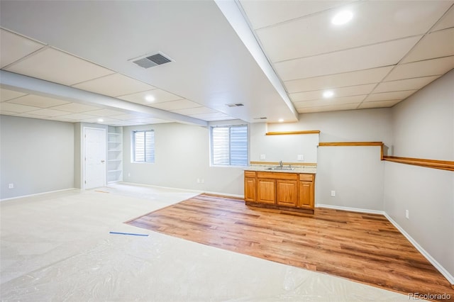 bar with visible vents, a drop ceiling, baseboards, and a sink
