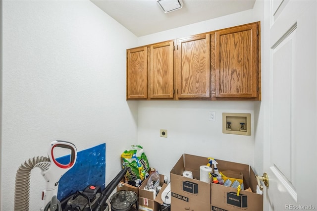 clothes washing area featuring cabinet space, hookup for an electric dryer, and hookup for a washing machine