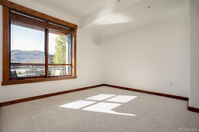 carpeted empty room featuring a mountain view