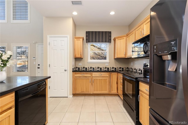 kitchen featuring light tile patterned flooring, light brown cabinetry, and black appliances