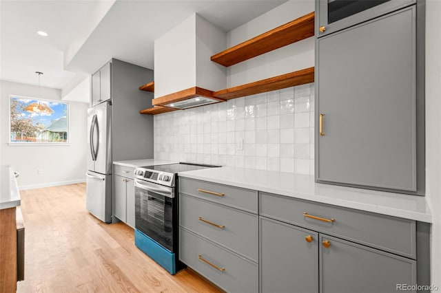 kitchen with open shelves, stainless steel appliances, backsplash, gray cabinetry, and light wood-style floors