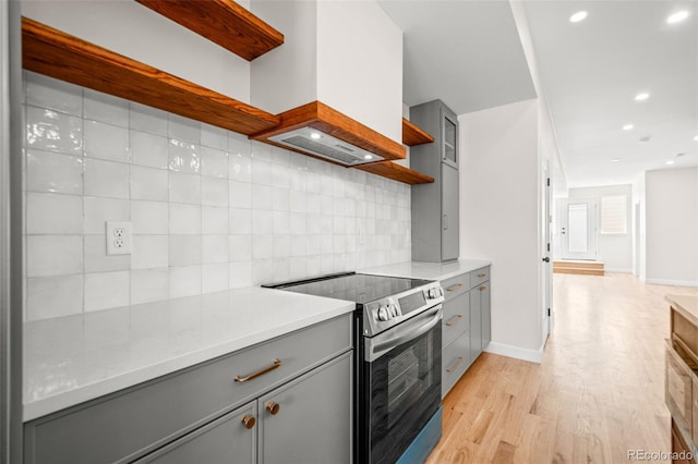 kitchen with light wood-style floors, open shelves, gray cabinets, and electric range