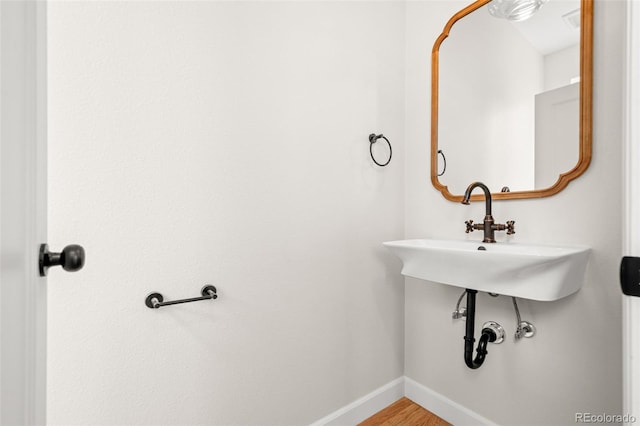 bathroom with wood finished floors and baseboards