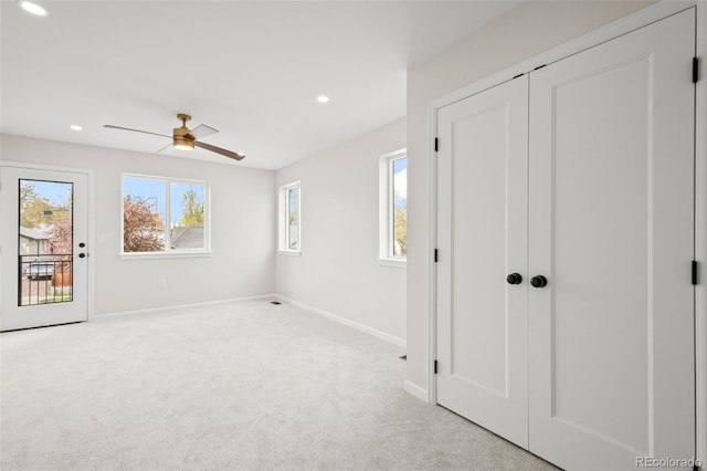 unfurnished bedroom featuring baseboards, multiple windows, carpet flooring, and access to outside
