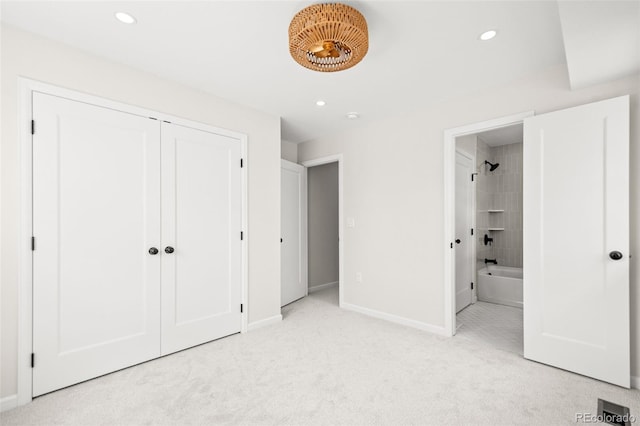 unfurnished bedroom with ensuite bathroom, light carpet, baseboards, and recessed lighting