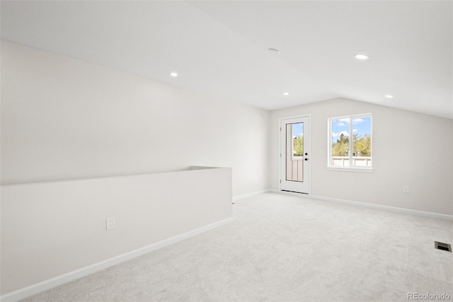 interior space with baseboards, recessed lighting, light colored carpet, and vaulted ceiling