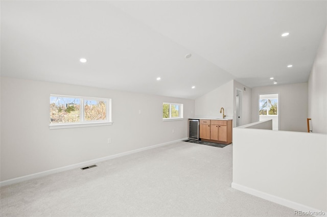 interior space with light colored carpet, visible vents, baseboards, and a sink