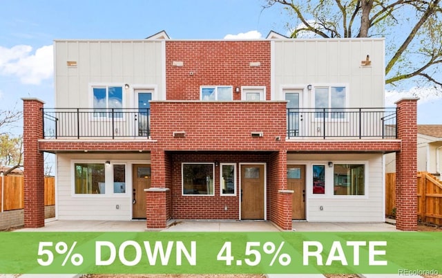 back of property with a balcony, a patio, and a fenced backyard