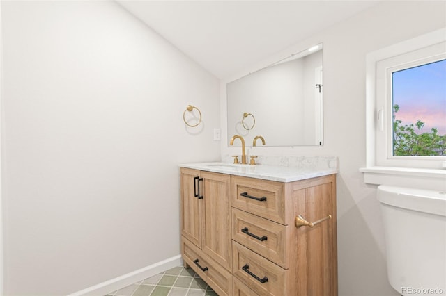 1052 N Knox Ct, Denver, CO 80204 - bathroom featuring vanity, toilet, baseboards, and vaulted ceiling