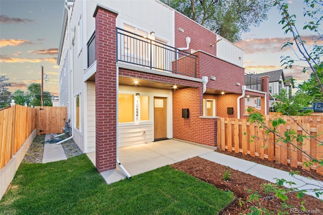 1052 N Knox Ct, Denver, CO 80204 - back of house featuring a balcony, a fenced backyard, and brick siding