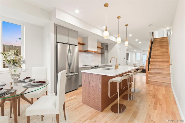 1052 N Knox Ct, Denver, CO 80204 - kitchen with appliances with stainless steel finishes, a sink, light wood-style flooring, modern cabinets, and recessed lighting