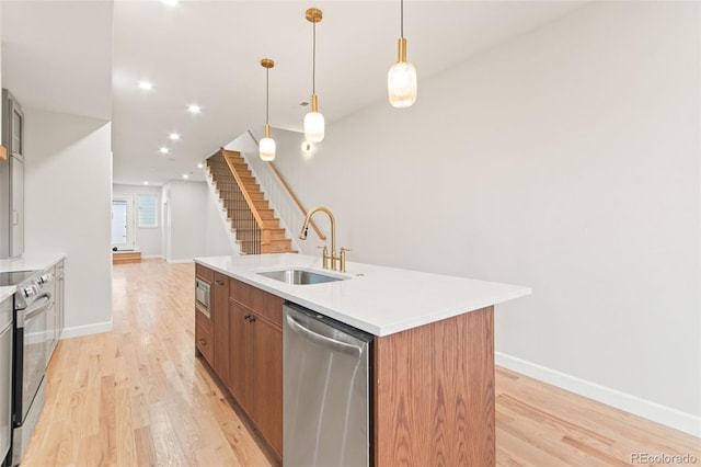 1052 N Knox Ct, Denver, CO 80204 - kitchen with appliances with stainless steel finishes, a sink, a center island with sink, light wood-style floors, and recessed lighting