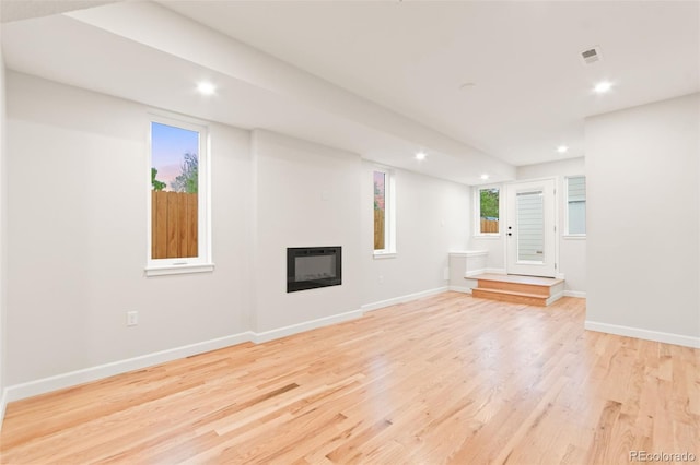 1052 N Knox Ct, Denver, CO 80204 - unfurnished living room featuring recessed lighting, light wood-type flooring, a glass covered fireplace, baseboards, and heating unit