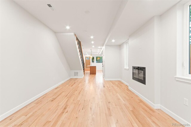 1052 N Knox Ct, Denver, CO 80204 - unfurnished living room with light wood-style floors, heating unit, baseboards, a glass covered fireplace, and recessed lighting