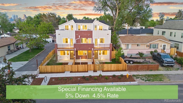 1052 N Knox Ct, Denver, CO 80204 - view of front of property with a balcony, a fenced front yard, board and batten siding, and a residential view