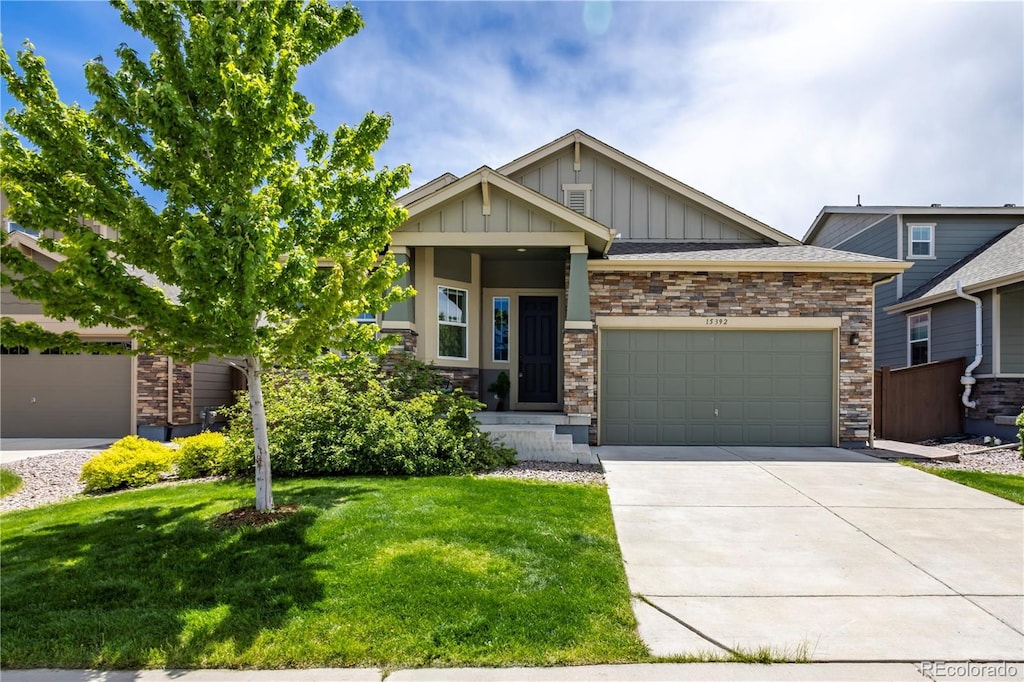 15392 W 49th Ave, Golden, CO 80403 - craftsman-style home with board and batten siding, a garage, a front lawn, concrete driveway, and stone siding