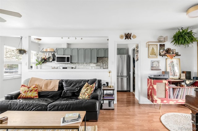 3202 S Dahlia St, Denver, CO 80222 - living area with ceiling fan, light wood-style floors, and baseboards