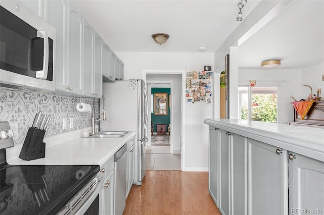 3202 S Dahlia St, Denver, CO 80222 - kitchen featuring stainless steel appliances, light countertops, backsplash, light wood-type flooring, and baseboards