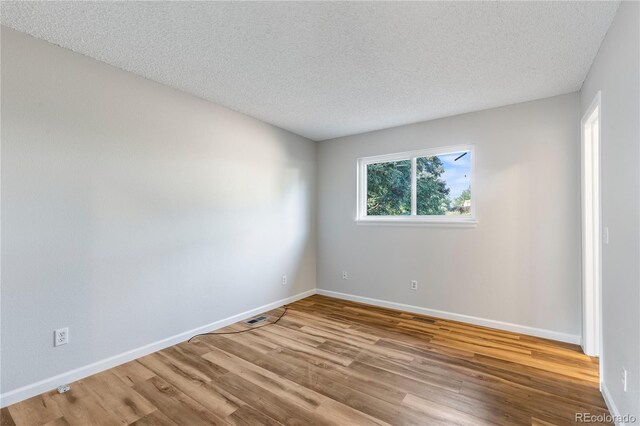 2452 S Kittredge Way, Aurora, CO 80013 - spare room featuring wood finished floors and a textured ceiling