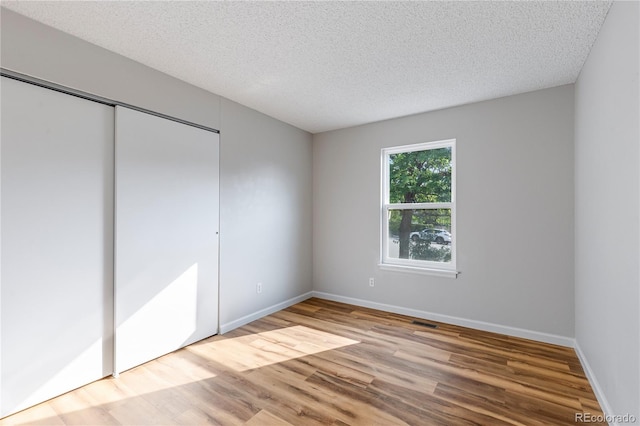 2452 S Kittredge Way, Aurora, CO 80013 - unfurnished bedroom with wood finished floors, a textured ceiling, and a closet