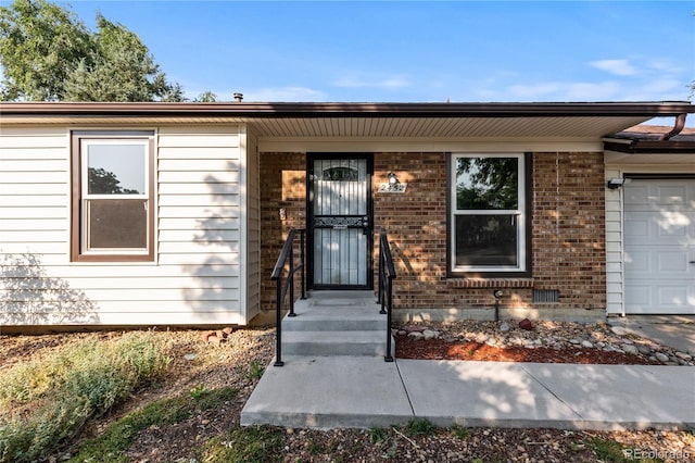 2452 S Kittredge Way, Aurora, CO 80013 - view of exterior entry with an attached garage and brick siding