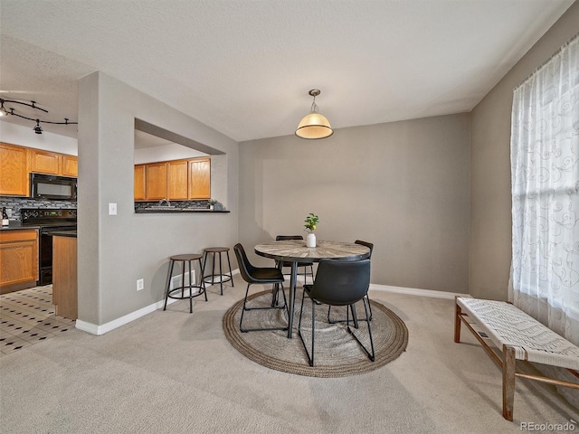 carpeted dining area featuring a textured ceiling