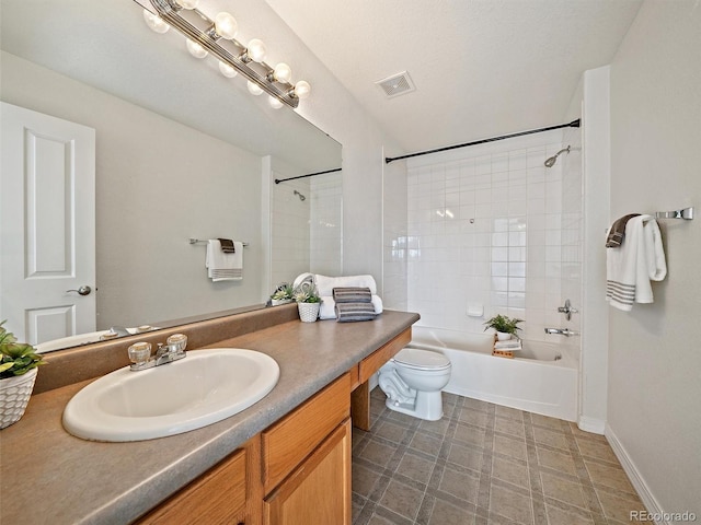 full bathroom with vanity, tiled shower / bath combo, and toilet