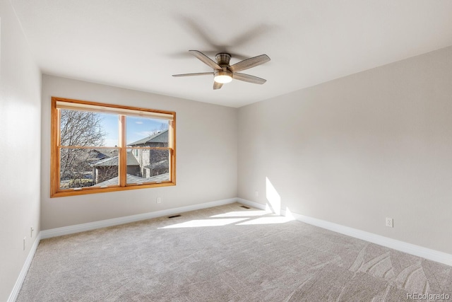 spare room with visible vents, baseboards, carpet, and a ceiling fan