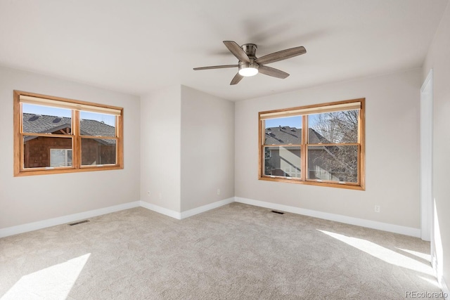 empty room with carpet flooring, baseboards, visible vents, and ceiling fan