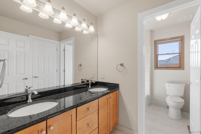 bathroom featuring a sink, toilet, a bath, and double vanity