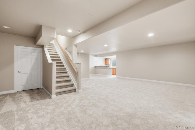 basement featuring recessed lighting, baseboards, stairs, and carpet