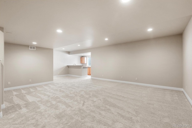 basement featuring visible vents, light carpet, bar, recessed lighting, and baseboards